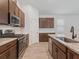 Features an island with granite countertops, stainless steel appliances, and dark wood cabinets at 12009 Walmsley Aly, Winter Garden, FL 34787