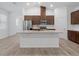 Kitchen features a spacious island with granite countertops, stainless steel appliances, and dark wood cabinets at 12009 Walmsley Aly, Winter Garden, FL 34787