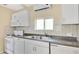 Well lit kitchen featuring white cabinets, a double sink, and an electric range at 1202 Randolph St, Sanford, FL 32771