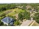 Home aerial view overlooking lush backyard, pond, and tree lined street at 1227 Juniper Hammock St, Winter Garden, FL 34787