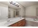 Bright bathroom with double sink vanity, soaking tub, and glass-enclosed shower at 1227 Juniper Hammock St, Winter Garden, FL 34787
