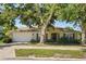 Inviting single-story home featuring a two-car garage, neutral color palette, and mature landscaping, all under a clear blue sky at 1227 Juniper Hammock St, Winter Garden, FL 34787
