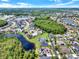 Aerial neighborhood view featuring a lake, and the community's well-spaced homes amidst lush greenery at 14036 Cherry Bush Ct, Orlando, FL 32828