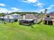 Expansive backyard featuring a screened lanai, lush lawn, and well-maintained landscaping on a sunny day at 14036 Cherry Bush Ct, Orlando, FL 32828