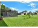 Lush green backyard featuring a screened-in patio, offering a perfect blend of indoor-outdoor living at 14036 Cherry Bush Ct, Orlando, FL 32828