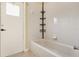Clean white tiled bathroom with tub and shower combo for a refreshing and functional space at 14036 Cherry Bush Ct, Orlando, FL 32828