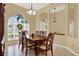 Elegant dining room with a wooden table, decorative chairs, and arched openings to adjacent living spaces at 14036 Cherry Bush Ct, Orlando, FL 32828