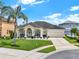 Charming single-story home with a manicured lawn, palm tree, and a welcoming front porch with decorative columns at 14036 Cherry Bush Ct, Orlando, FL 32828