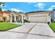 Well-maintained home featuring an attached two-car garage, a long driveway, and manicured landscaping at 14036 Cherry Bush Ct, Orlando, FL 32828