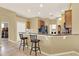 Open concept kitchen with breakfast bar and stainless steel refrigerator, featuring tile flooring at 14036 Cherry Bush Ct, Orlando, FL 32828