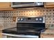 Close up of kitchen with stainless steel cooktop, microwave and granite countertops with tile backsplash at 14036 Cherry Bush Ct, Orlando, FL 32828