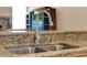 Kitchen sink with stainless steel faucet and granite countertops, featuring a tiled backsplash at 14036 Cherry Bush Ct, Orlando, FL 32828