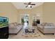 Spacious living room with tile flooring, a ceiling fan, comfortable sofas, and sliding glass doors to the outdoor area at 14036 Cherry Bush Ct, Orlando, FL 32828