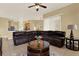 Open concept living room and kitchen with a large leather sectional sofa and tile flooring at 14036 Cherry Bush Ct, Orlando, FL 32828