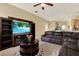 Spacious living room with a large television and a dark leather sectional sofa at 14036 Cherry Bush Ct, Orlando, FL 32828