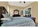 This is a main bedroom featuring a bed, ceiling fan, dresser with mirror, and large windows at 14036 Cherry Bush Ct, Orlando, FL 32828
