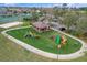 Community playground featuring colorful play structures, a covered picnic area, and lush green space at 14036 Cherry Bush Ct, Orlando, FL 32828