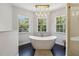 Bright bathroom featuring a modern soaking tub with chandelier and natural light from the windows at 14205 Conifer Dr, Orlando, FL 32832