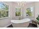 Elegant bathroom with a free-standing tub, chandelier, and plenty of natural light at 14205 Conifer Dr, Orlando, FL 32832