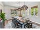 Dining room featuring a live edge table, black chairs, woven light fixtures, and natural light at 14205 Conifer Dr, Orlando, FL 32832