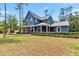 Inviting blue home with a wraparound porch and manicured front lawn at 14205 Conifer Dr, Orlando, FL 32832