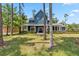 Stunning blue home featuring a manicured lawn, wraparound porch, and double-door entry at 14205 Conifer Dr, Orlando, FL 32832