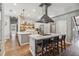 An open-concept kitchen with island seating, stainless appliances, and light wood flooring at 14205 Conifer Dr, Orlando, FL 32832
