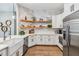 Bright kitchen with white cabinets, open shelves, stainless steel appliances, and an island at 14205 Conifer Dr, Orlando, FL 32832