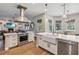 A modern kitchen features white cabinets, stainless steel appliances, and an open layout into the living room at 14205 Conifer Dr, Orlando, FL 32832
