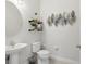 Half bathroom with a sleek vessel sink and round mirror above a floating shelf feature at 1450 Chelsea Manor Cir, Deland, FL 32724