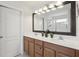 Bathroom featuring double sink vanity, large mirror, and modern lighting fixtures at 1450 Chelsea Manor Cir, Deland, FL 32724