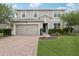 Charming two-story home with a brick driveway, manicured lawn and beautiful landscaping at 1450 Chelsea Manor Cir, Deland, FL 32724