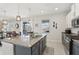 Open kitchen view to the living room boasting granite counters, stainless appliances, and an island with a sink at 1450 Chelsea Manor Cir, Deland, FL 32724
