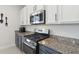 Close up of kitchen with granite countertops, stainless steel appliances, and gray and white cabinets at 1450 Chelsea Manor Cir, Deland, FL 32724