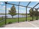 Screened lanai with lake view, landscaping, and outdoor lighting at 1450 Chelsea Manor Cir, Deland, FL 32724