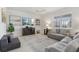 Bright living room with neutral walls, tile floors, lots of comfy seating and a large TV at 1450 Chelsea Manor Cir, Deland, FL 32724
