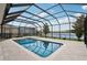 Screened pool and lanai with lake view and lush landscaping at 1450 Chelsea Manor Cir, Deland, FL 32724