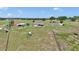 Areal view showcasing an expansive estate, featuring a home, outbuildings, and fenced pasture at 16386 Se 156Th Place Rd, Weirsdale, FL 32195