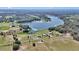 Expansive aerial view showcasing the property's proximity to a serene lake and lush greenery at 16386 Se 156Th Place Rd, Weirsdale, FL 32195