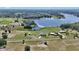 Aerial view showcasing a serene home with lake access, outbuildings, and extensive property at 16386 Se 156Th Place Rd, Weirsdale, FL 32195