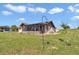 Backyard showcases a mix of structures including home, sunroom and shed, against the backdrop of a vast, green yard at 16386 Se 156Th Place Rd, Weirsdale, FL 32195