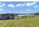 Metal barn structure on a grassy, fenced field near a lake at 16386 Se 156Th Place Rd, Weirsdale, FL 32195