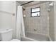 Bathroom featuring tile walls, shower-tub combination, and natural light from the window at 16386 Se 156Th Place Rd, Weirsdale, FL 32195
