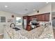 Well-appointed kitchen features granite countertops and a stainless steel refrigerator with lots of space at 16386 Se 156Th Place Rd, Weirsdale, FL 32195
