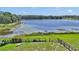 Breathtaking lake view with lush greenery and a charming wooden fence, inviting tranquility at 16386 Se 156Th Place Rd, Weirsdale, FL 32195
