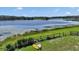 Scenic lake view from a sprawling green lawn featuring a canoe and a rustic wooden fence at 16386 Se 156Th Place Rd, Weirsdale, FL 32195