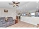 Comfortable living room features a ceiling fan, tile flooring, and an open layout to the kitchen and dining area at 16386 Se 156Th Place Rd, Weirsdale, FL 32195