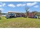 View of the yard with a trailer, storage container, shed and other features against a blue sky backdrop at 16386 Se 156Th Place Rd, Weirsdale, FL 32195