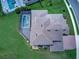 Aerial view featuring a home with a pool enclosed by black screens, a brick driveway, and lush green grass at 16768 Sanctuary Dr, Winter Garden, FL 34787