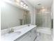 Well lit bathroom featuring dual sinks, a shower over bath and a modern grey color scheme at 16768 Sanctuary Dr, Winter Garden, FL 34787